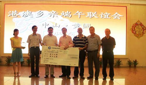 香港中山僑商會(huì)會(huì)長(zhǎng)謝偉森(右四)率多名副會(huì)長(zhǎng)向黃圃端午龍舟賽組委會(huì)致贈(zèng)捐款支票和紀(jì)念品，黃圃鎮(zhèn)副鎮(zhèn)長(zhǎng)